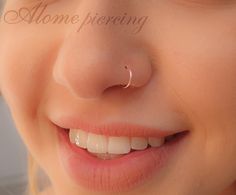 a close up of a person with a nose ring on their nose and the words home piercing written in front of them