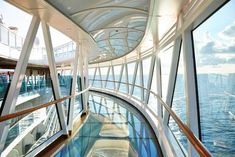 the inside of a cruise ship looking down at the water and sky from the upper deck