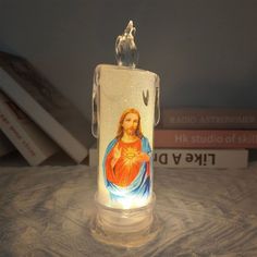 an illuminated candle with the image of jesus on it