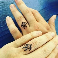 two people with matching tattoos on their fingers