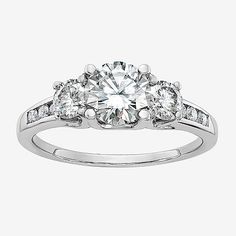 a three stone engagement ring with diamonds on the shoulders and side stones set in white gold