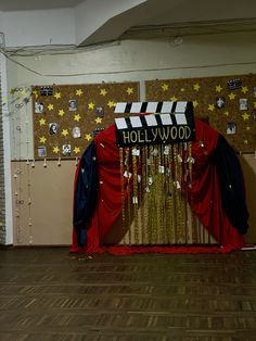 a hollywood themed stage set up with red curtains and stars on the wall behind it