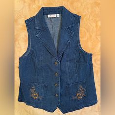 Denim & Co. Stretch Denim Embroidered Button Front Vest - Indigo Denim Wash, Size X-Tra Small In-Vest In Your Appearance. This Denim Vest Serves You Well In A Variety Of Ensembles. The Stretch Semi-Fitted Design Moves With You Easily And Follows The Lines Of The Body For Added Wearing Ease. Princess Seams And Embroidery Detail The Top For A Total Tailored Look. From Denim & Co.(R) Fashions. Four-Button Front, Two Front Pockets With Embroidery Size Xs(4) Sem-Fitted; Length Measurements Xs 23-1/2" Body 99% Cotton/1% Spandex; Embroidery 100% Polyester Machine Wash, Tumble Dry Originally Purchased Off Qvc. Never Worn. Still In Bag. Blue Embroidered Denim Vest, Embroidered Medium Wash Denim Top, Fitted Embroidered Denim Vest Casual, Casual Embroidered Fitted Denim Vest, Cowl Neck Shirt, Grey Two Piece, Half Zip Top, Knit Shrug, Purple Pants