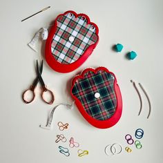 two red cases sitting on top of a table next to scissors and other crafting supplies