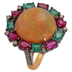 Beautiful Antique Victorian 14K Yellow Gold & silver Fire Opal Emerald & Diamond Cocktail Ring. This incredible cocktail ring is crafted in 14k yellow gold & silver . The center holds a natural vibrant opal with an incredible play of color pattern. The opal is surrounded by Emerald & diamond and has a beautiful design on the shank of the ring. Metal: 14K Yellow Gold Weight: 1.91 Grams silver:2.58 Size: 7 us Diamonds: Approximately 0.27 Carat Ruby - 1.38 Carat Emerald : 0.94 Carat Opal: Approximately 6.03 Carat Diamond Cocktail Ring, Diamond Cocktail Rings, Ring Metal, Ruby Diamond, Gem Stone, Emerald Diamond, Cocktail Ring, Antique Victorian, Cocktail Rings