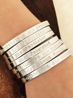 a woman's wrist with four bracelets that say she is the best person