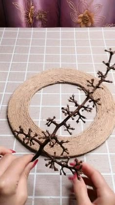 two hands are working on a piece of wood that has been made to look like branches