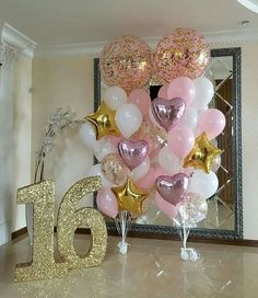 a table with balloons and numbers on it in the shape of heart shapes, sitting next to a mirror