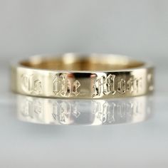 a gold wedding band with the word love written on it