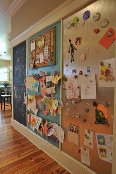 a bulletin board with pictures and magnets on it in an office hallway or playroom