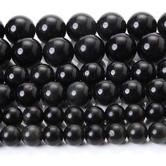 black onyxite beads with white dots are stacked up against each other in rows