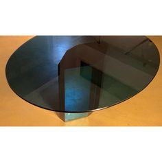 a round glass table with metal legs on a wooden floor in an empty room or dining area