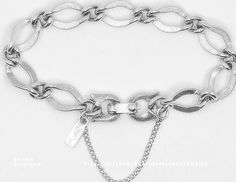 Vintage 1960's Monet silver finish charm 7 inch bracelet with safety chain.  The links are textured.  This vintage bracelet had one owner and was worn very little.  Excellent like new condition. Retro Silver Metal Charm Bracelet, Vintage Silver Chain Bracelet, Safety Chain, Vintage Bracelet, Silver Charm Bracelet, Vintage Bracelets, Chain Link Bracelet, Silver Charms, Link Bracelets