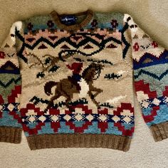 a sweater with horses on it is laying on the floor