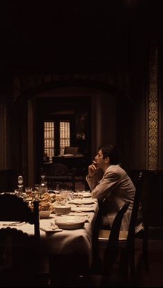 a man sitting at a dinner table in the dark