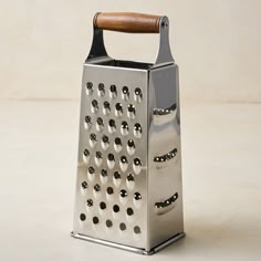 a metal grater with a wooden handle