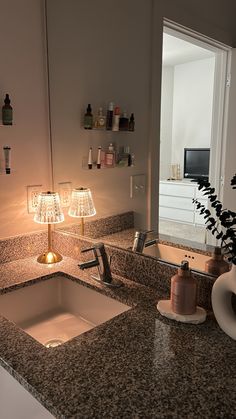 a bathroom sink sitting under a mirror next to a light on a wall above it