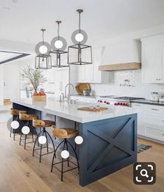 a kitchen island with four stools in front of it and an open floor plan