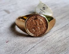 Small gold coin ring 9ct gold(375%) signet ring eagle 1971 Quarto peso replica I brought these 9ct gold replica coins in an antique shop 25 yrs ago.so I don't know the history.. I have set them in a very small gold signet style ring Coin measures 10mm Top is 11mm Tapiers to 3mm at the back Sits very flat on the finger Suitable as a pinkie ring THIS IS A SMALL RING Available in a silver base also Gold Coin Ring, Pinkie Ring, Silver Coin Ring, Two Tone Ring, Gold And Silver Coins, Small Ring, Coin Ring, Antique Shop, Gold Coin