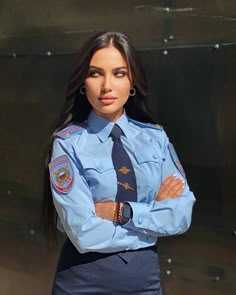 a woman in uniform standing with her arms crossed