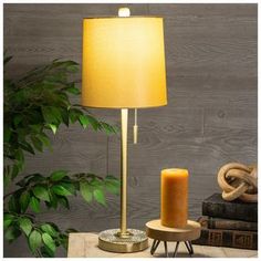 a table lamp sitting on top of a wooden table next to a potted plant