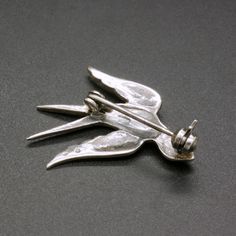 A charming vintage 835 silver pin, decorated with sparkling marcasite crystals. This dainty mid century 1950's brooch is featuring a small bird, a swallow. Would add a nice accent to any outfit. The brooch will be shipped in a gift box. The brooch measures 1 1/5 Inches wide by 9/10 inches tall (3.0 cm x 2.3 cm) Weight: 2.7 grams Hallmarked for 835 silver Rollover clasp Excellent vintage condition, with lovely patina. The standard shipping for this item is with tracking. If you prefer a faster sh 1950s Jewelry, Mid Century Jewelry, Vintage Bird, Golden Ring, Bird Brooch, Silver Pin, Dog Pin, Garnet Stone, Vintage Birds