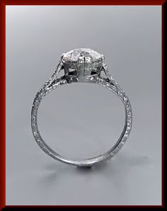 Set in platinum and dating from the 1920s, this is a captivating engagement ring. It holds an old European cut diamond that weighs approx. 1.60 ct in the center. The diamond is a J in color and SI2 in clarity. Flowing down the sides are 8 smaller accent diamonds accompanied inspired etching creating an eloquently enthralling piece. We offer resizing, free of charge. ER 408M SIX MONTH LAY-AWAY AVAILABLE - PLEASE CONTACT ME TO SET UP A PLAN Antique Diamond Ring With Vvs Clarity, Victorian Diamond Cut Promise Ring, Victorian Style Diamond Cut Promise Ring, Vintage White Gold Diamond Cut Ring, Antique Platinum Diamond Ring With Center Stone, Art Deco Asscher Cut Ring For Anniversary, Art Deco Round Cut Ring For Marriage, Vintage Platinum Round Ring, Antique Platinum Rings With Vvs Clarity