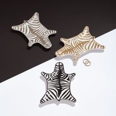 two star shaped brooches sitting next to each other on a black and white table