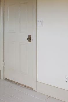 an open door in a white room with tile flooring