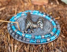 a metal tray with blue beads and a small animal on it sitting in the grass