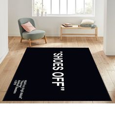 a black rug with the words keep off on it in front of a chair and window