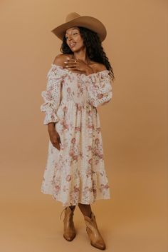 Printed in perfect florals, this midi dress features a smocked bodice, a tiered silhouette, and poet sleeves that can be worn on or off the shoulders for the dreamiest fit. Made of soft cotton and complete with eyelet detailing, this dress is the epitome of charming elegance. lined bodice and skirt unlined sleeves pockets // paired with the free people new frontier western boots in peru