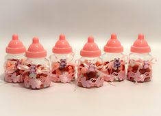 four baby bottles filled with candy and candies