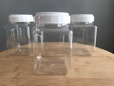 three clear jars sitting on top of a wooden table