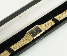 This elegant Accurist gold-colored watch boasts a rectangular case with a black dial, featuring a date function that enhances its utility as a date watch. The metal bracelet lends a unisex appeal, making it a versatile choice for any gender. It also comes with its original box, adding to its value and appeal. Dimensions: Bracelet Length: up to 20.5 cm (8.1 inches) - adjustable Case Width: 2.5 cm (1 inches) Case Length: 2.8 cm (1.1 inches) Bracelet Width: 1.5 cm (0.6 inches) Condition: The watch Yellow Gold Watch With Rectangular Dial For Gift, Yellow Gold Watch With Rectangular Dial As Gift, Gold Watch Accessories With Date Display For Gift, Gold Rectangular Watch Accessories For Formal Occasions, Gold Watches With Date Display And Rectangular Dial, Yellow Gold Watch Accessories With Date Display For Gift, Rectangular Gold Watch Accessories For Gift, Rectangular Watches With Date Display, Rectangular Watches With Date Display For Anniversary