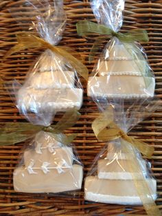 three small cakes wrapped in plastic sitting on top of a wicker tablecloth covered basket