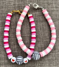 two pink and white bracelets with hearts on them