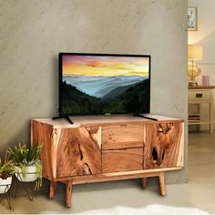 a flat screen tv sitting on top of a wooden cabinet