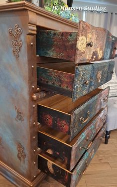 an old dresser with many drawers and knobs on the doors is painted in different colors