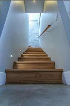 the stairs are made of wood and have white walls