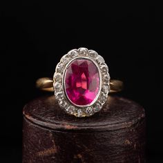 A beautiful Victorian oval cluster ring dating circa 1900, handcrafted in 18k yellow gold with a Platinum top, featuring a synthetic Ruby surrounded by 18 old cut diamonds weighing combined approx. 0.90 carat. The shoulders narrow as they meet the cluster giving a slim and elegant look to the ring. Period: Vitorian 1900s. Condition: Good condition commensurate to age. Material: 18k yellow gold, weighing 3.6 grams, acid tested. Gemstone: Oval synthetic Ruby measuring 9mm x 7mm, set in Platinum. D Victorian Ruby Ring, Antique Diamond Ring, Ruby Diamond Ring, Ruby Diamond Rings, Antique Diamond Rings, Ring Antique, Antique Diamond, Ruby Diamond, Cluster Ring