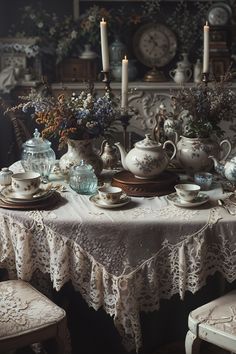 a table topped with lots of dishes covered in lace