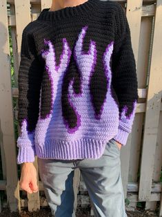 a person wearing a purple and black knitted sweater with the letters y on it