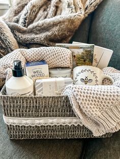 a wicker basket filled with personal care items on a couch next to a blanket