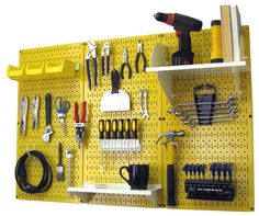 a yellow pegboard with tools hanging on it