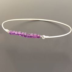 "Amethyst Bead Bracelet - Amethyst Bracelet - February Birthstone Jewelry - A row of 10 faceted amethyst gemstone beads has been transformed into an elegant amethyst beaded bangle bracelet with your choice of sterling silver or 14k gold filled bangle band. Perfect for a February birthstone bracelet. This February amethyst jewelry can be personalized with an initial dangle. Simply add to cart to make a customized amethyst beaded bracelet; http://www.etsy.com/listing/84670605/add-an-initial-charm- Adjustable Amethyst Beaded Bracelets With Birthstone, Purple Beaded Birthstone Bracelets As Gift, Purple Beaded Birthstone Bracelets For Gift, Purple Birthstone Beaded Bracelets As Gift, Purple Birthstone Beaded Bracelets For Gift, Spiritual Amethyst Beaded Birthstone Bracelet, Purple Amethyst Birthstone Bracelet, Purple Rondelle Beaded Bracelets As Gift, Adjustable Amethyst Rondelle Bracelets