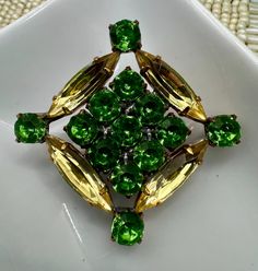 GORGEOUS GREEN! Vintage rhinestone Czech button with citrus yellow Navette and gorgeous green round stones. This one is a stunner! ONLY ONE OF THESE! DON'T MISS OUT ON THIS ONE! Has been in storage for decades. In excellent condition, new old stock. Metal shank.  Please see pic for measurements in inches.  Thank you for stopping by! Green Round Brooch For Formal Occasions, Green Round Brooch Jewelry, Green Round Brooch, Formal Green Rhinestone Brooches, Green Rhinestone Wedding Brooch, Green Rhinestone Wedding Brooches, Elegant Green Rhinestone Brooches, Vintage Green Rhinestone Brooches, Green Vintage Rhinestone Brooches