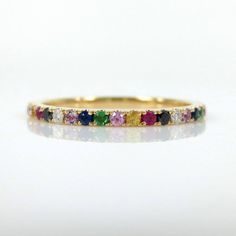 This gorgeous Eternity Band is available in your choice of 18K White, Yellow, and Rose Gold.  It features 0.55 carats of pavé set multi-colored brilliant diamonds and gemstones all the way around creating a repeating rainbow effect. The Rainbow eternity band is the perfect complement to any engagement ring or as stackable bands. Total carat weight: 0.55cts Based on ring size: 6.5 •Diamonds•Black Diamonds•Blue Sapphires•Pink Sapphires•Yellow Sapphires•Ruby•Amethyst•Tsavorites ( Green Garnets) *** Multicolor 14k Gold Jewelry For Wedding, Rainbow Cubic Zirconia Jewelry For Wedding, Rainbow Cubic Zirconia Wedding Jewelry, Multicolor Brilliant Cut Jewelry For Weddings, Multicolor Round Band Wedding Jewelry, Multicolor Halo Jewelry For Wedding, Rainbow Multi-stone Wedding Jewelry, Rainbow Multi-stone Jewelry For Wedding, Pave Wedding Bands