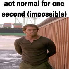 a man standing next to a fence with the words act normal for one second second impossible