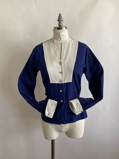 "Unusual tuxedo style 1940s handmade blouse is made with a navy cotton and a white waffled cotton for the collar, chest and cuffs. Shell buttons adorn the neck and lower bodice of the shirt, while metal and glass buttons detail the bib front and (doubled)cuffs. Pleating in the back and front of the bodice give the blouse a bit of shape. Blouse is in good condition, there is a yellow stain in the back of the neck that I have not been able to remove(though I'll give it another try however, it is n Fitted Cotton Tops With Sailor Collar, Fitted Navy Vintage Tops, Fitted Vintage Navy Tops, Cotton Sailor Collar Top For Work, Fitted Cotton Blouse For Vintage Fashion, Handmade Blouse, Tuxedo Style, Acrylic Sweater, Silk Chiffon Dress